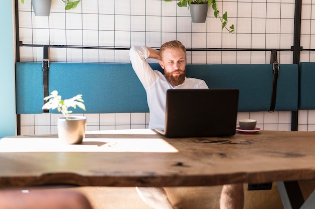 Bel uomo barbuto a un tavolo di lavoro