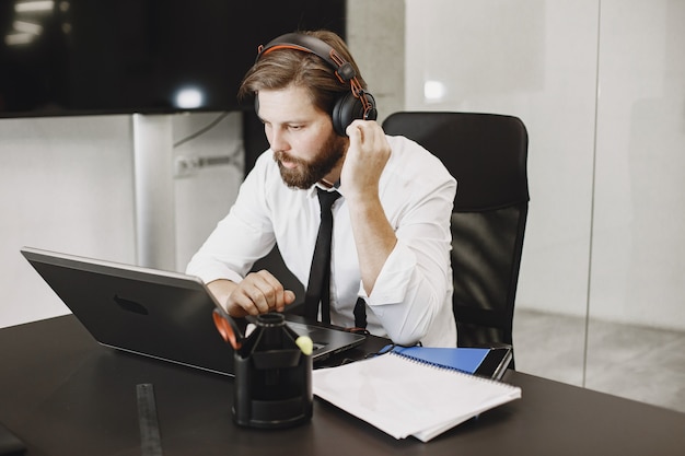 Bell'uomo con una camicia bianca. Uomo d'affari che lavora online.