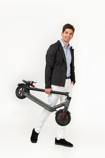 Bell'uomo in sella a uno scooter elettrico isolato su sfondo bianco per studio
