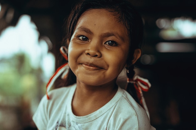 bella bambina indonesiana con trecce e nastri. Bella ragazza balinese con grandi occhi neri. Bali, novembre 2021