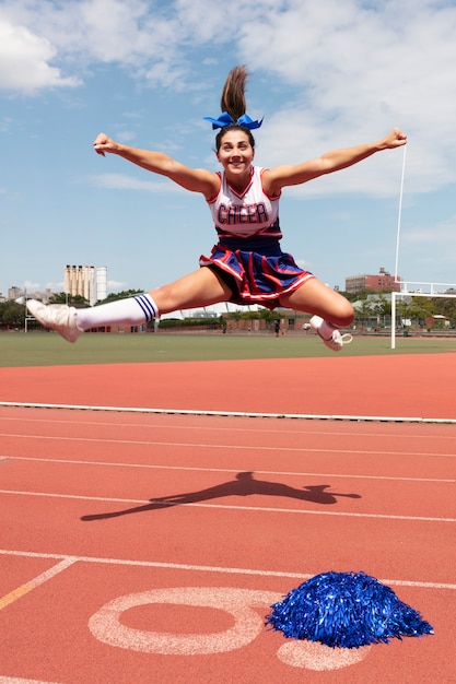 Bella cheerleader femminile in uniforme carina