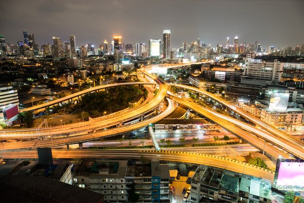 Bella città con luci vicino alla sua autostrada più trafficata di notte.