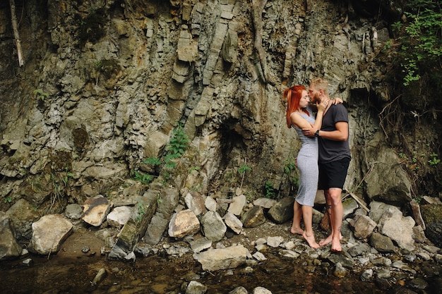 Bella coppia che si abbraccia vicino a un fiume di montagna