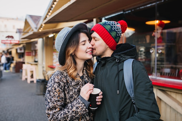 Bella coppia gioiosa agghiacciante, abbracciando sulla strada nel periodo natalizio. Vere emozioni d'amore, divertirsi, godersi lo stare insieme, appuntamenti, relazioni romantiche, felicità insieme.