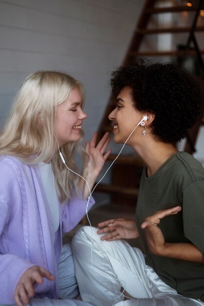 Bella coppia lesbica che ascolta musica con gli auricolari