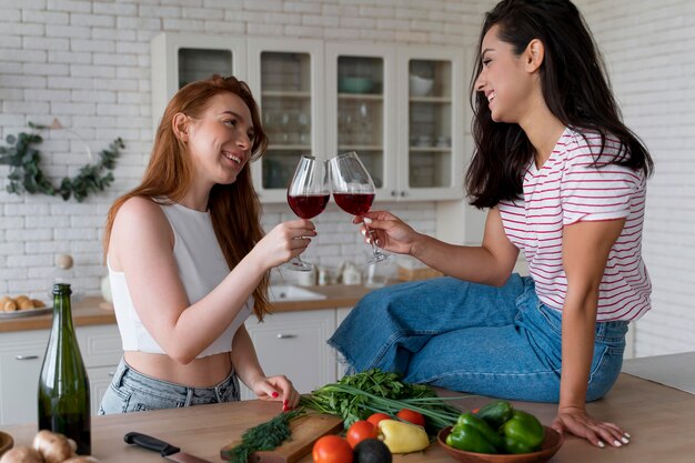 Bella coppia lesbica che fa il tifo con dei bicchieri di vino