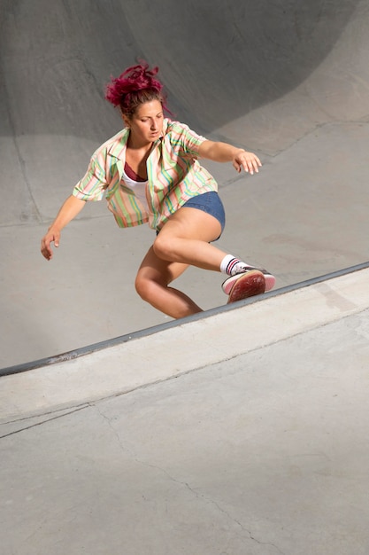 Bella donna a tutto campo sullo skateboard