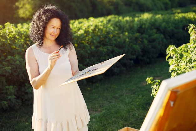 Bella donna adulta che assorbe un campo di estate