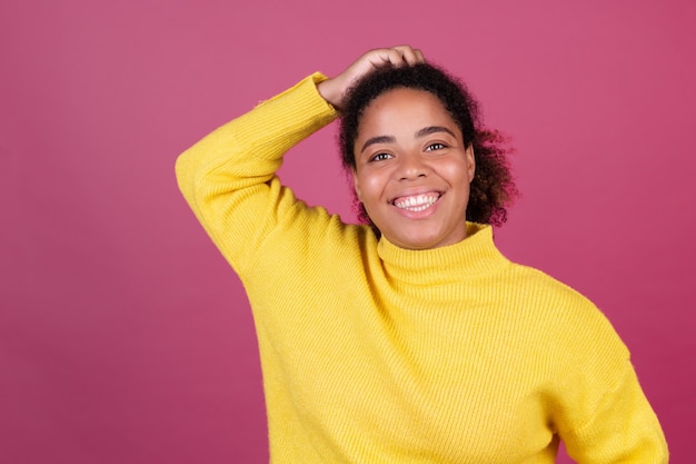 Bella donna afroamericana sulla parete rosa sorridente felice allegro positivo