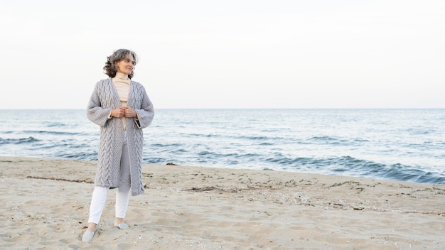 Bella donna anziana che si gode il suo tempo in spiaggia