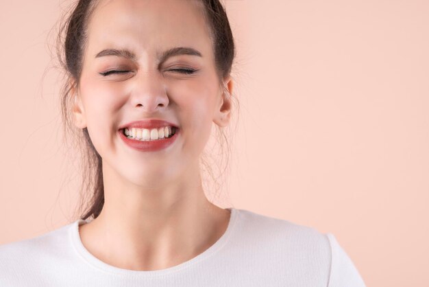 Bella donna asiatica attraente viso primo piano vestito casual ridere e grande sorriso felicità sorpresa espressione bella donna asiatica sorriso a trentadue denti ampia bocca colore sfondo