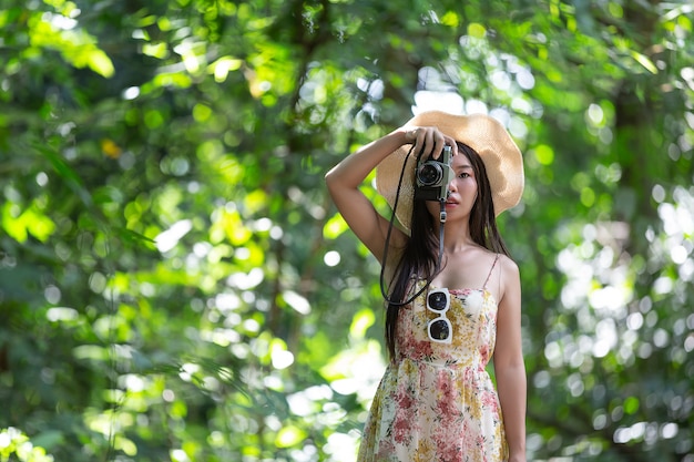bella donna asiatica che cattura foto nel parco