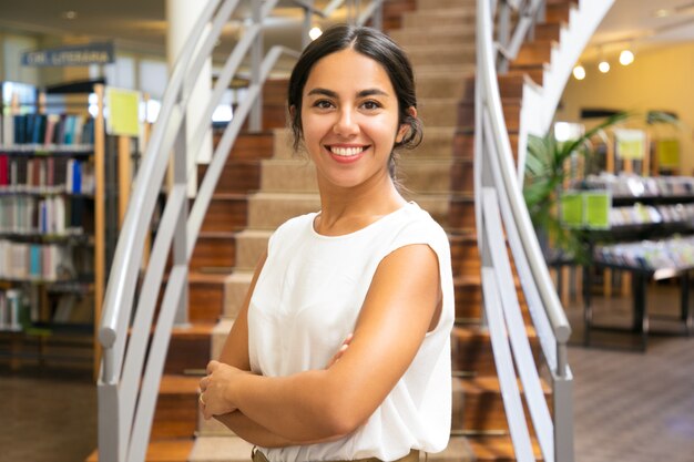 Bella donna asiatica che posa alla biblioteca