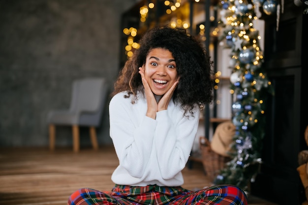 Bella donna attraente adorabile felicissima si siede sul pavimento