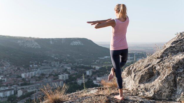 Bella donna bionda a praticare yoga all'aperto