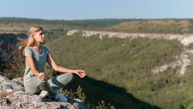 Bella donna bionda che fa yoga all'aperto