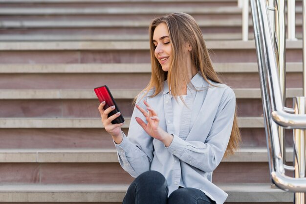 Bella donna bionda che per mezzo del telefono