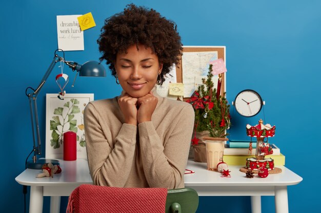 Bella donna castana che rimane nel suo posto di lavoro