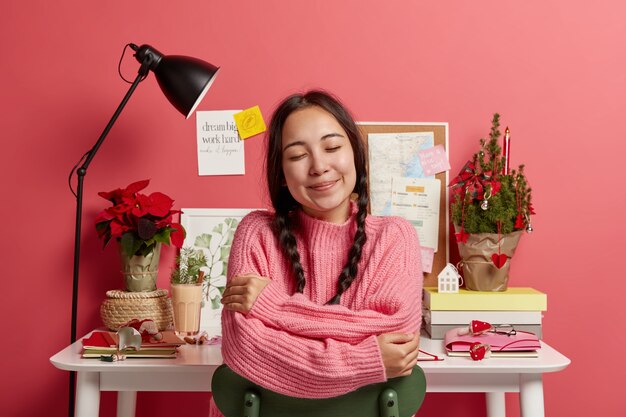 Bella donna castana che rimane nel suo posto di lavoro