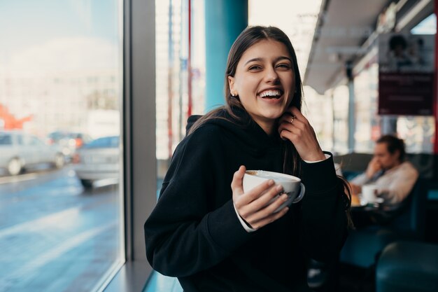 Bella donna che beve caffè e sorridente