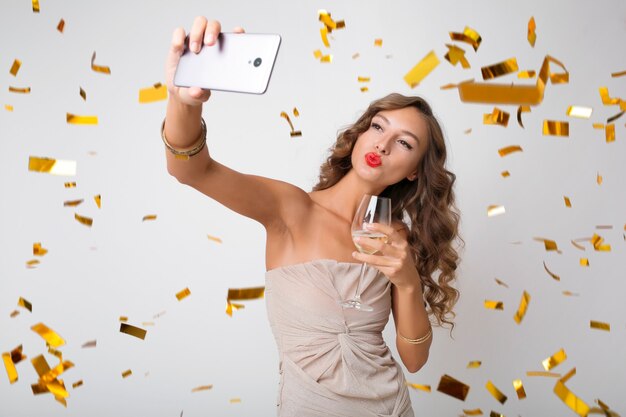 Bella donna che celebra il nuovo anno bevendo champagne