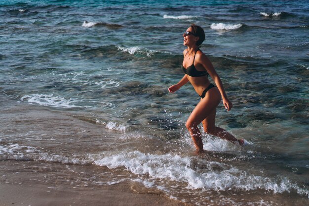 Bella donna che corre in riva al mare