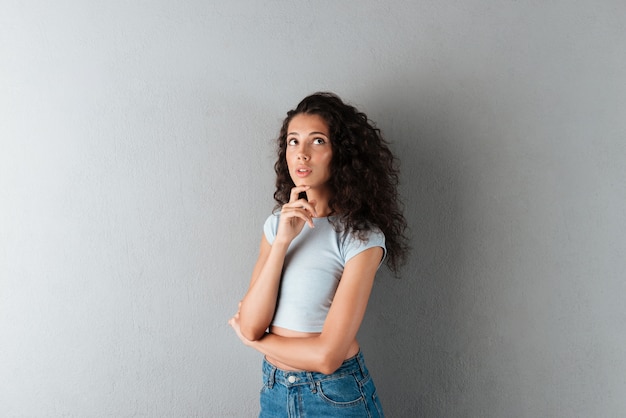 Bella donna che esamina macchina fotografica isolata seriamente