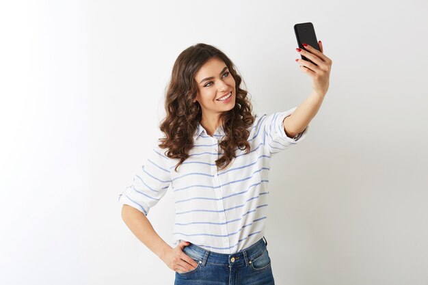 Bella donna che fa selfie foto sul cellulare, sorridente, felice, islolated, capelli ricci, stato d'animo positivo, guardando a porte chiuse, modello attraente in posa