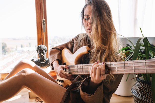 Bella donna che fissa la chitarra elettrica