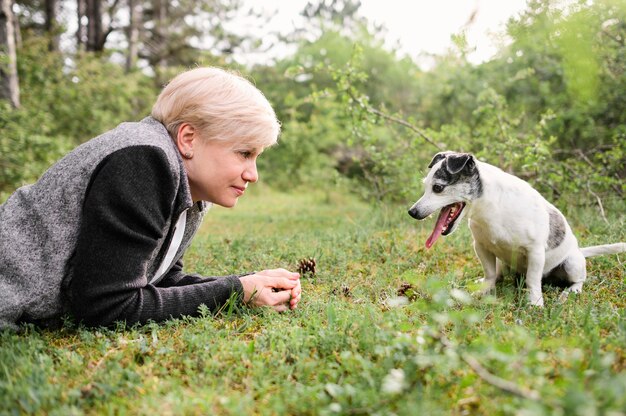 Bella donna che gioca con il suo cane nel parco