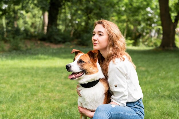 Bella donna che gode del tempo fuori con il cane