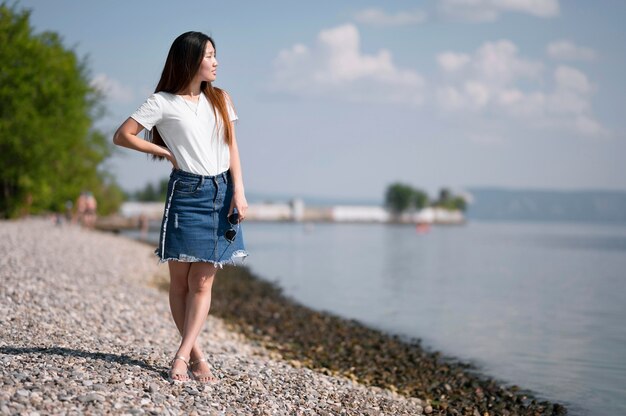 Bella donna che guarda lontano sulla spiaggia con copia spazio