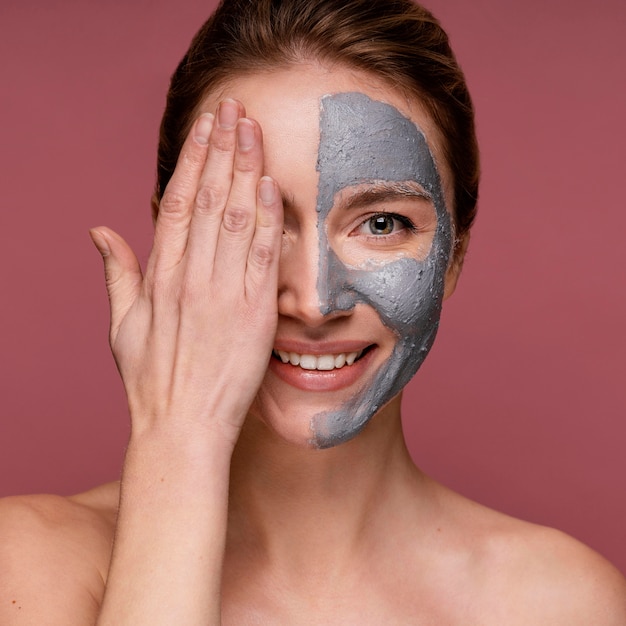 Bella donna che ha metà del suo viso che copre con la maschera