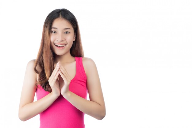 Bella donna che indossa una camicia rosa con un sorriso felice su uno sfondo bianco