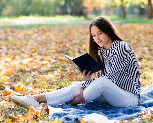 Bella donna che legge nel parco