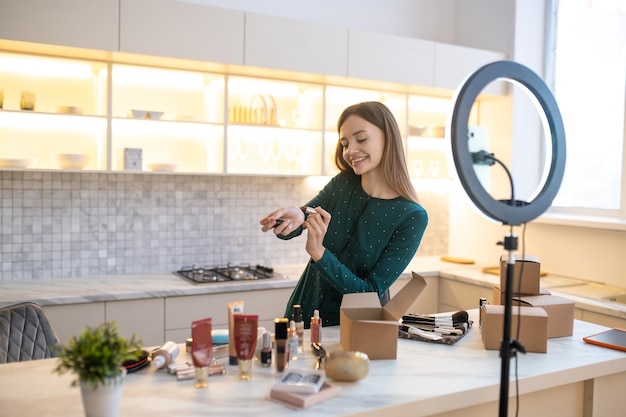 Bella donna che mostra nuovi cosmetici e sembra coinvolta