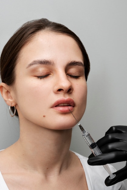 Bella donna che ottiene riempitivi per le labbra in clinica