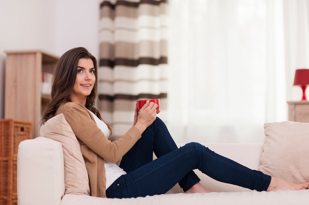 Bella donna che si distende con una tazza di caffè