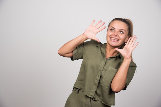 Bella donna che si sente felice sul muro grigio.