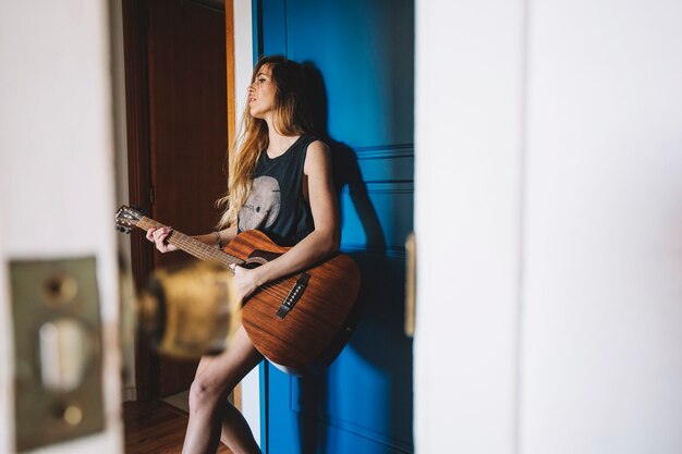 Bella donna che suona la chitarra nel corridoio