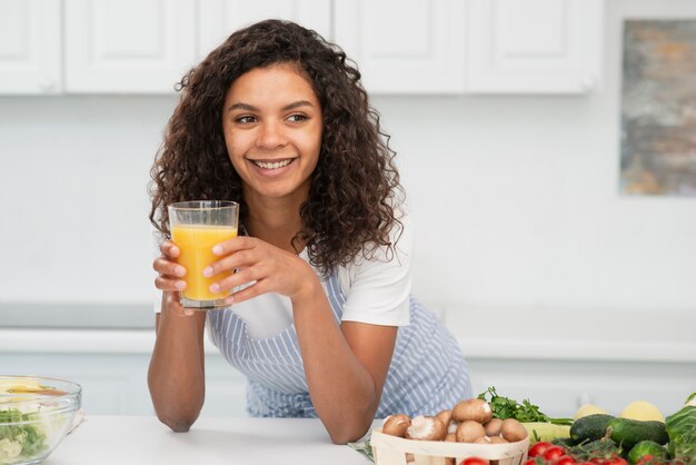 Bella donna che tiene un bicchiere di succo