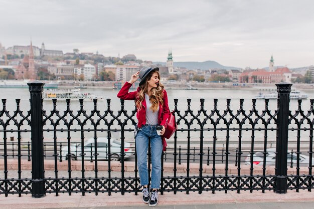 Bella donna con capelli ondulati in posa al ponte