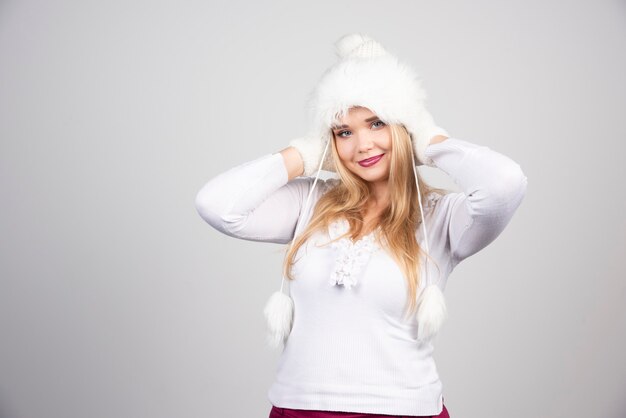 Bella donna con cappello bianco e maglione bianco.