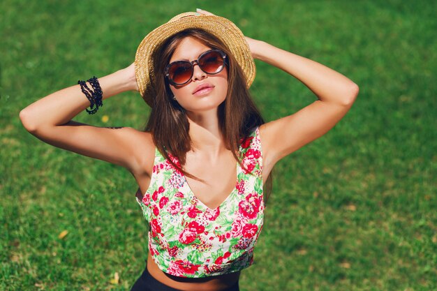 Bella donna con cappello in posa sull'erba