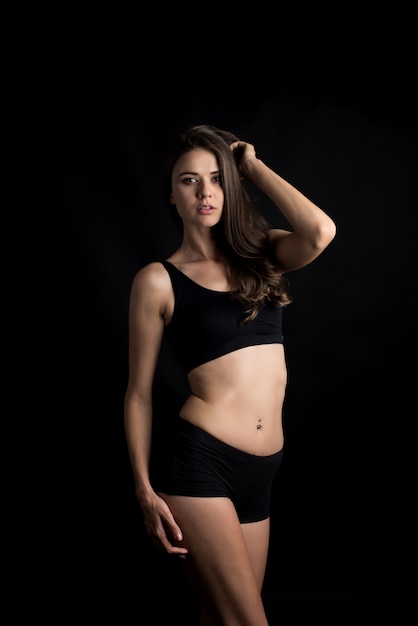 Bella donna con corpo sano su sfondo nero