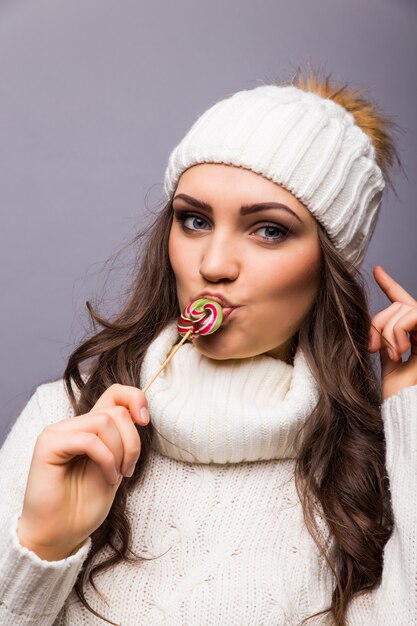 Bella donna con il cappello bianco che tiene Lollipop