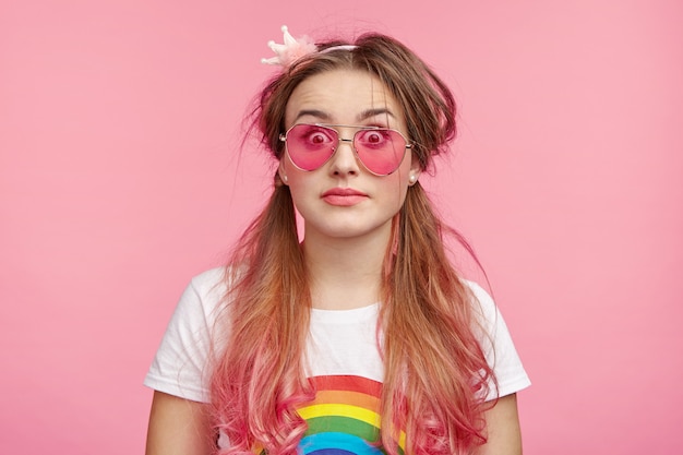 Bella donna con occhiali da sole rosa alla moda