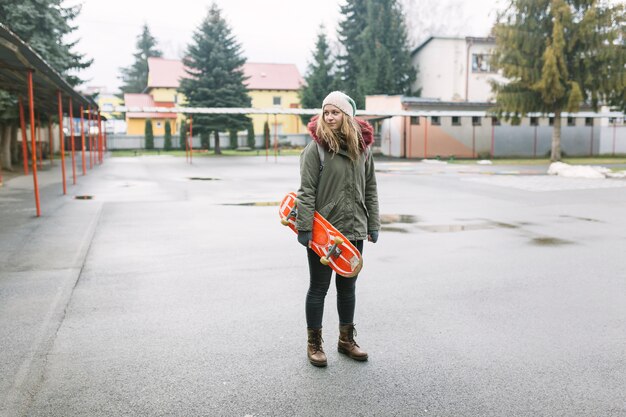 Bella donna con skateboard nel parco