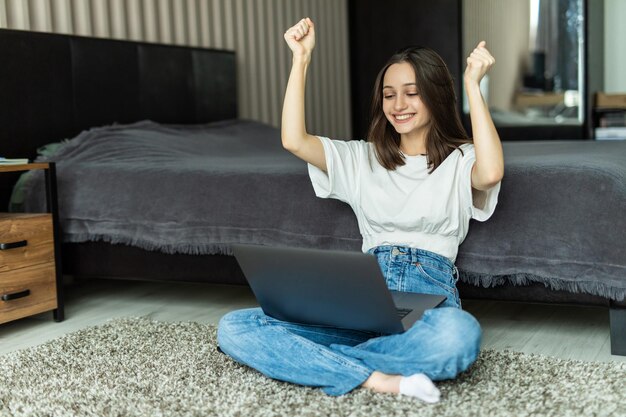 Bella donna con un laptop moderno seduto a casa