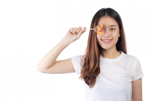 Bella donna con un sorriso felice che tiene una caramella della mano, isolata su priorità bassa bianca.